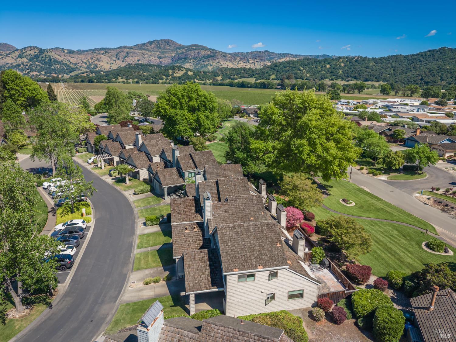 Aerial view of a Yountville home and neighborhood, with vineyards and hills in the distance.