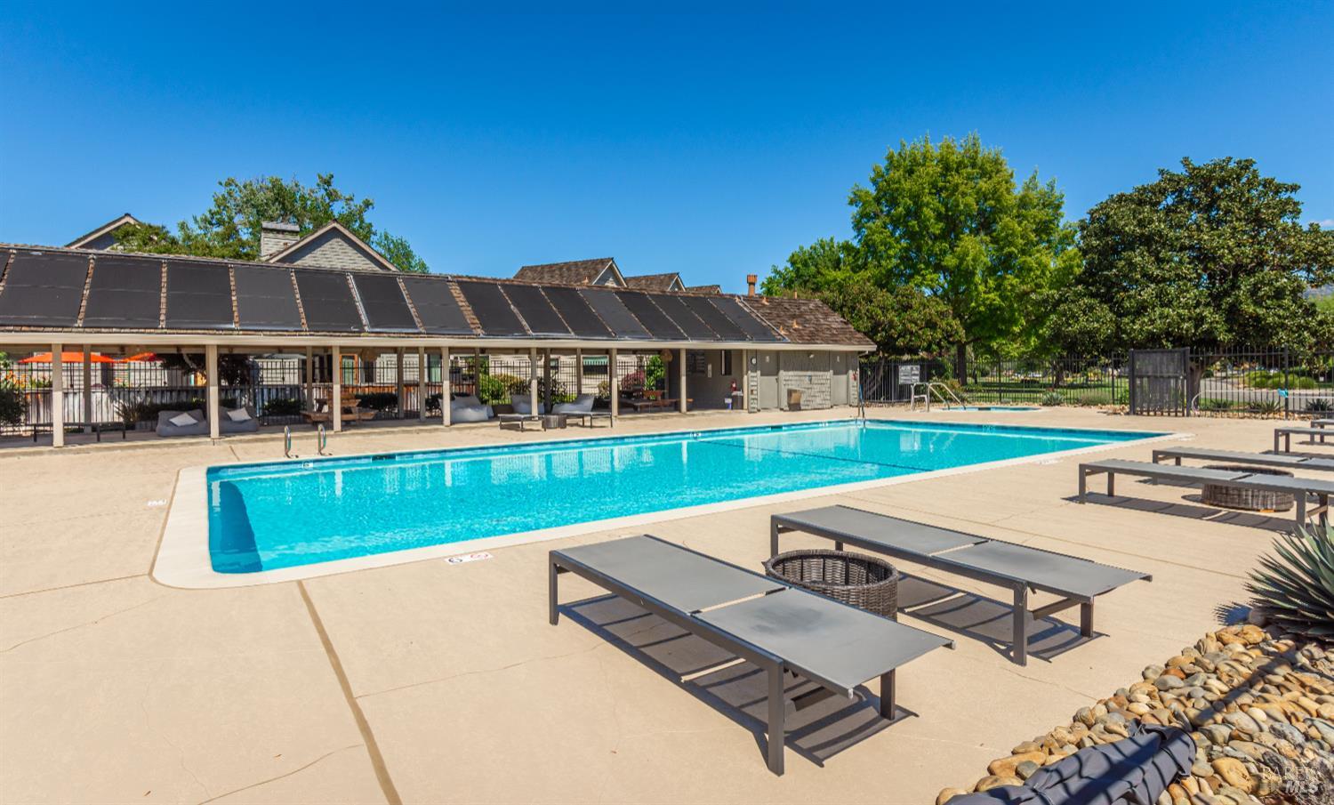 Community swimming pool with lounge chairs and a shaded cabana.