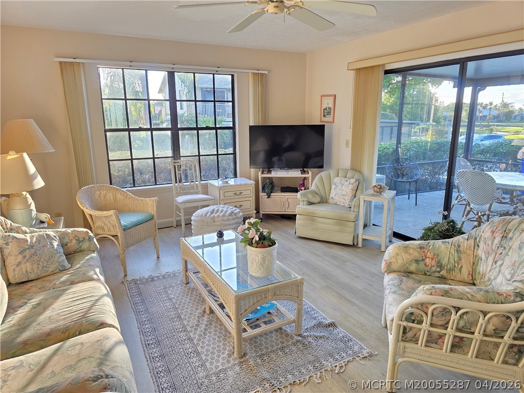 Furnished living room with wicker seating, floral sofas, and sliding glass doors to a patio.