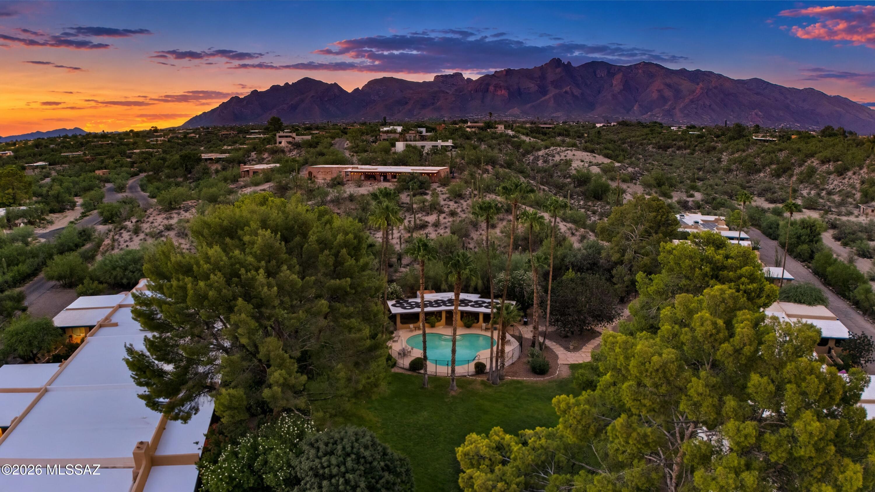 Aerial view of a Tucson home and pool with the Santa Catalina Mountains at sunset.