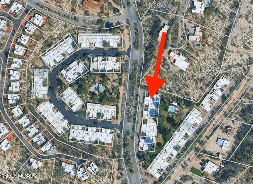 Aerial view of the property, marked by a red arrow among nearby homes and roads.