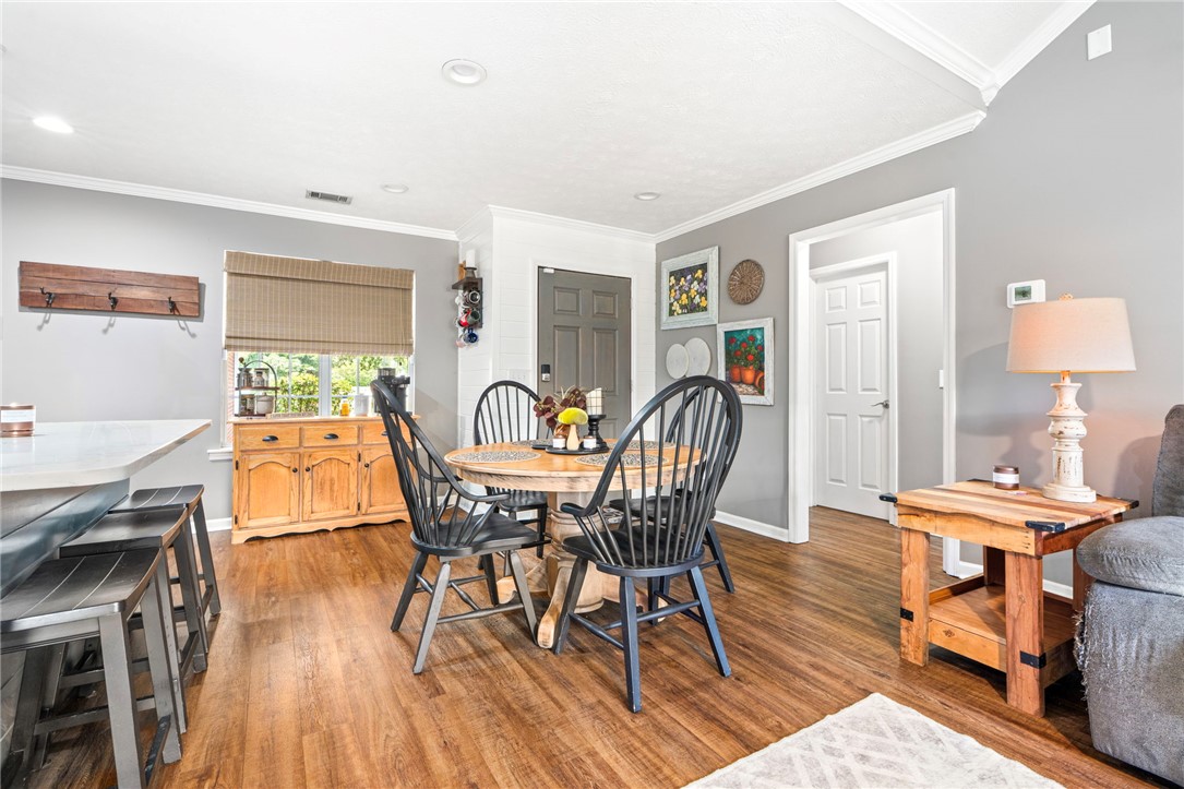 Dining room with a round table, black spindle-back chairs, and warm wood floors.