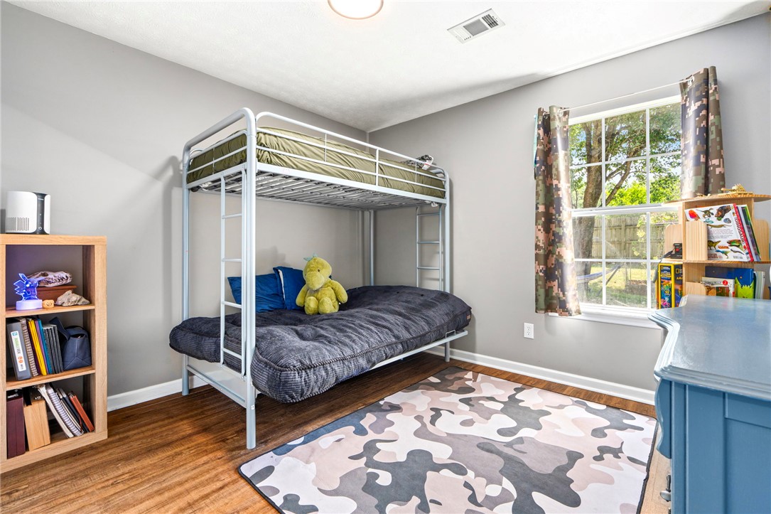 Bedroom with a metal bunk bed, camouflage-patterned curtains, and a blue desk.