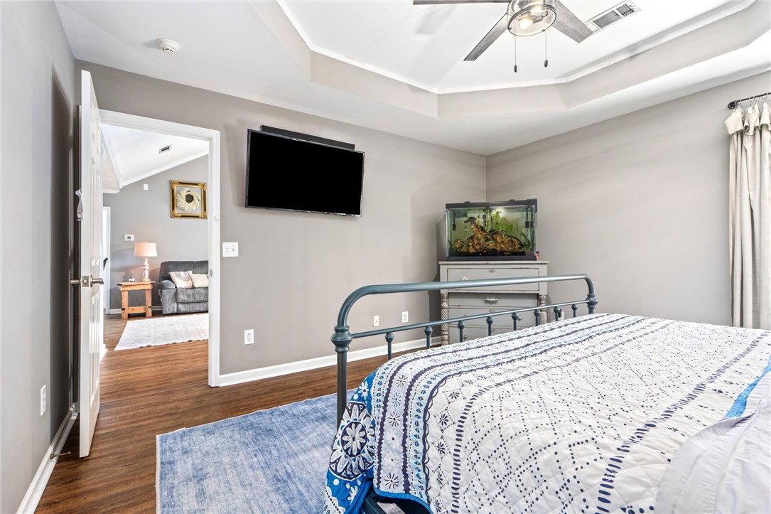 Bedroom with a patterned bedspread, wall-mounted television, and aquarium.