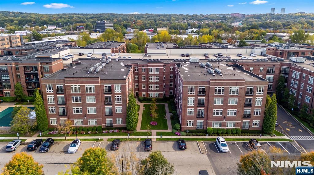 Aerial view of a brick condominium complex with a landscaped courtyard and parking.
