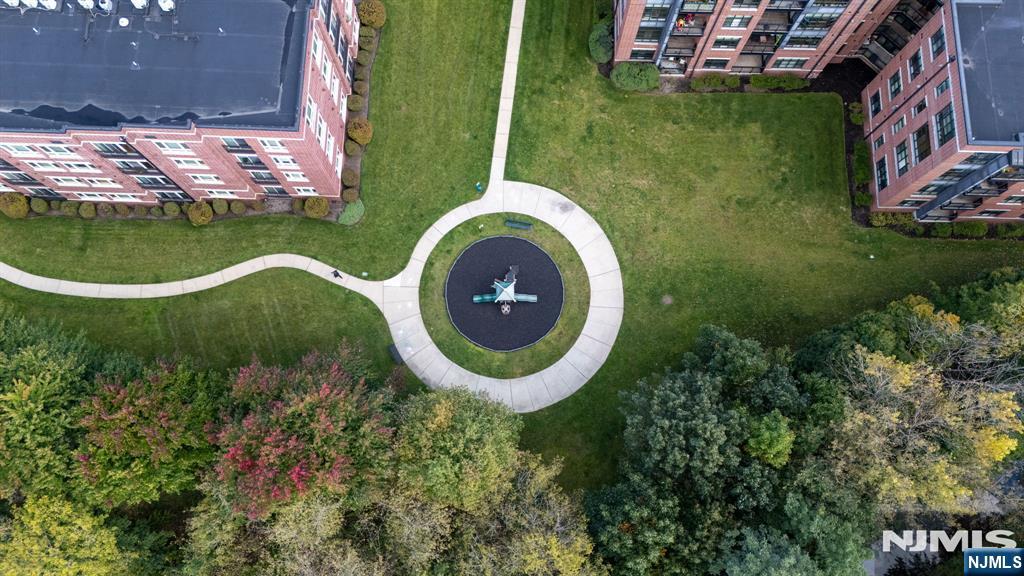 Aerial view of apartment buildings around a landscaped courtyard with winding paths and a central sculpture.