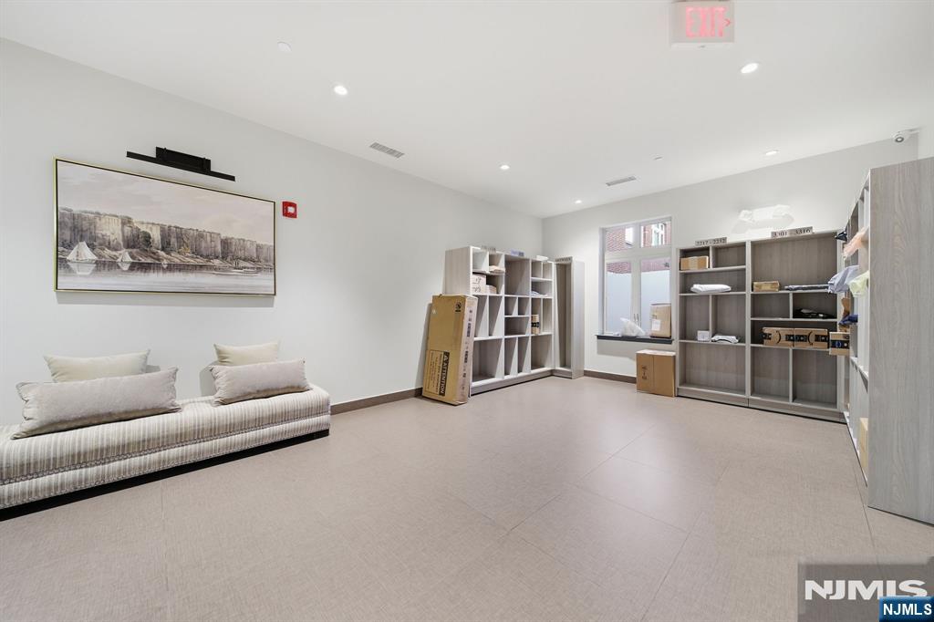 Communal room with a striped sofa, open shelving, and boxes.