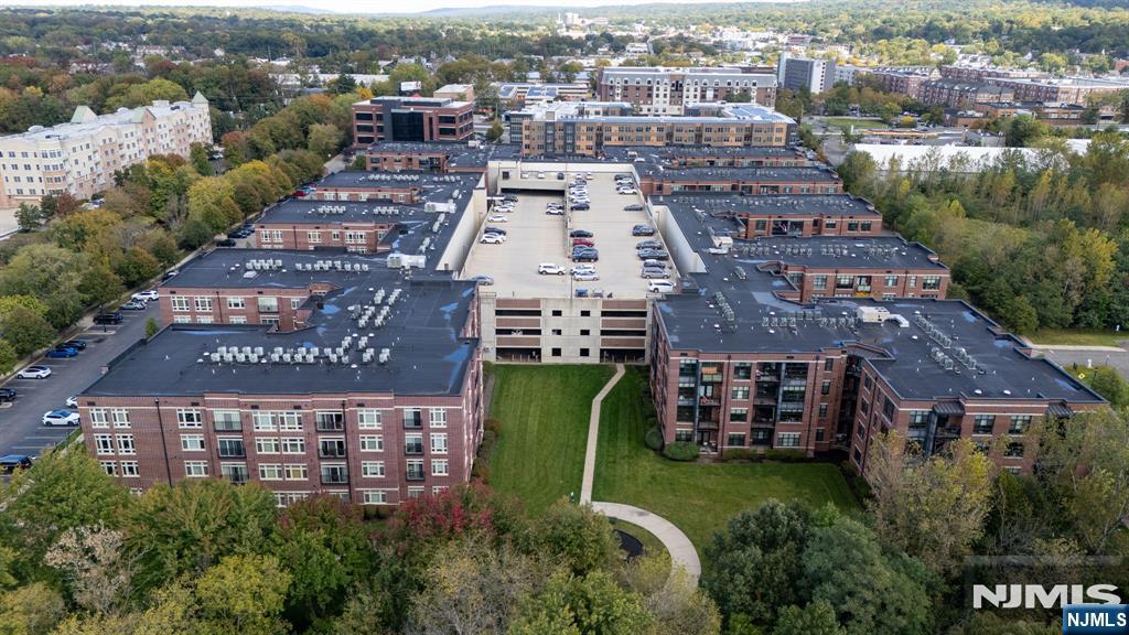 Aerial view of a residential complex with a central parking garage and landscaped courtyard.