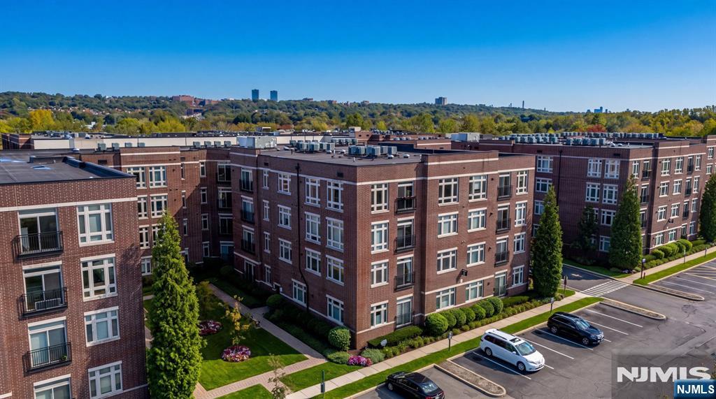 Aerial view of a red-brick apartment complex with landscaped grounds and a parking lot.