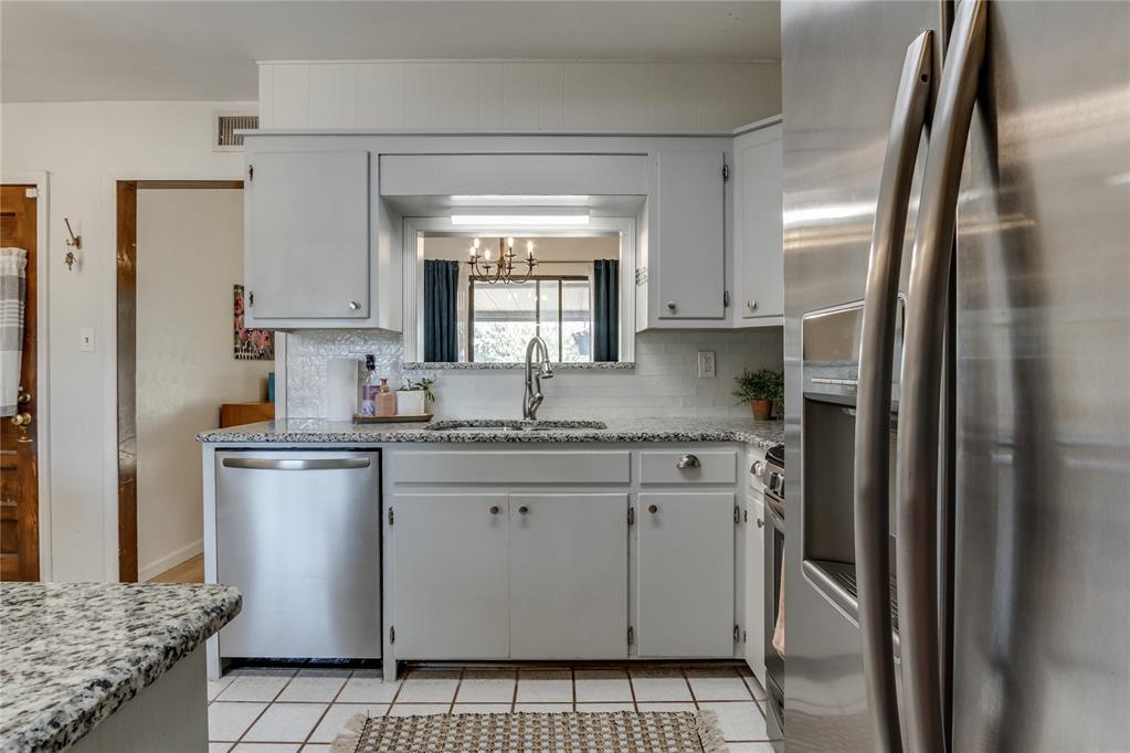 Kitchen with white cabinets, granite counters, and stainless steel appliances.