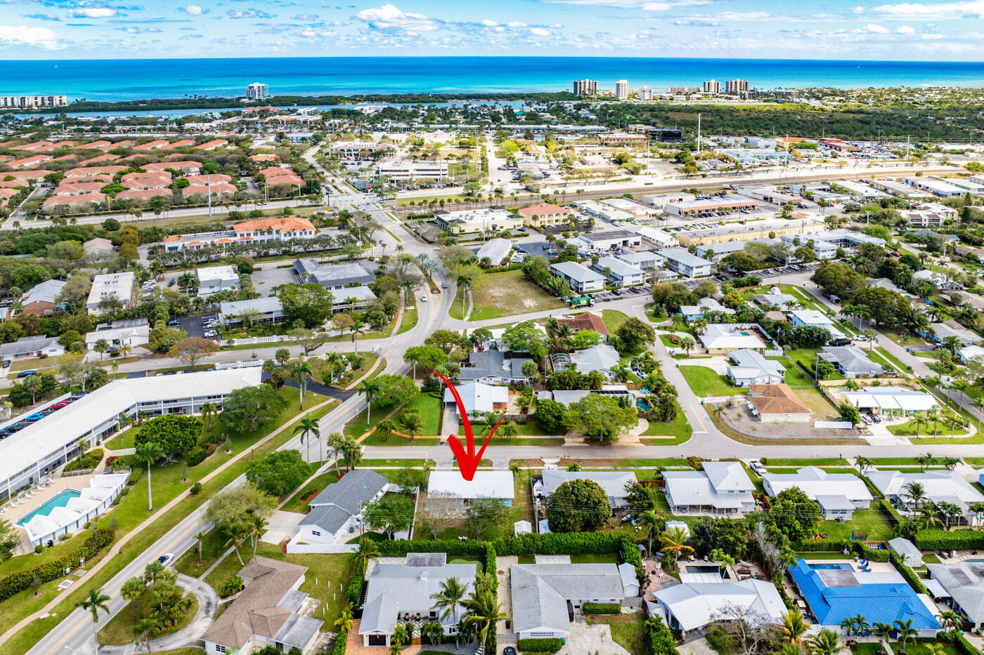 Aerial view of the marked home in a coastal neighborhood, with the Atlantic Ocean beyond.
