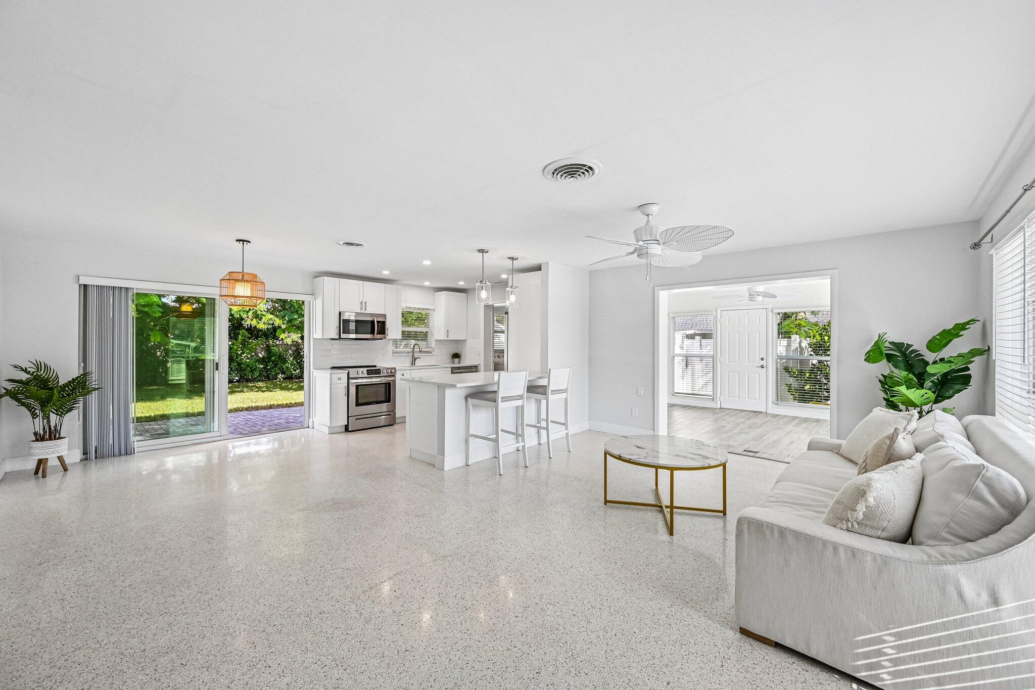 Open living room and kitchen with a breakfast island and sliding glass doors to the garden.