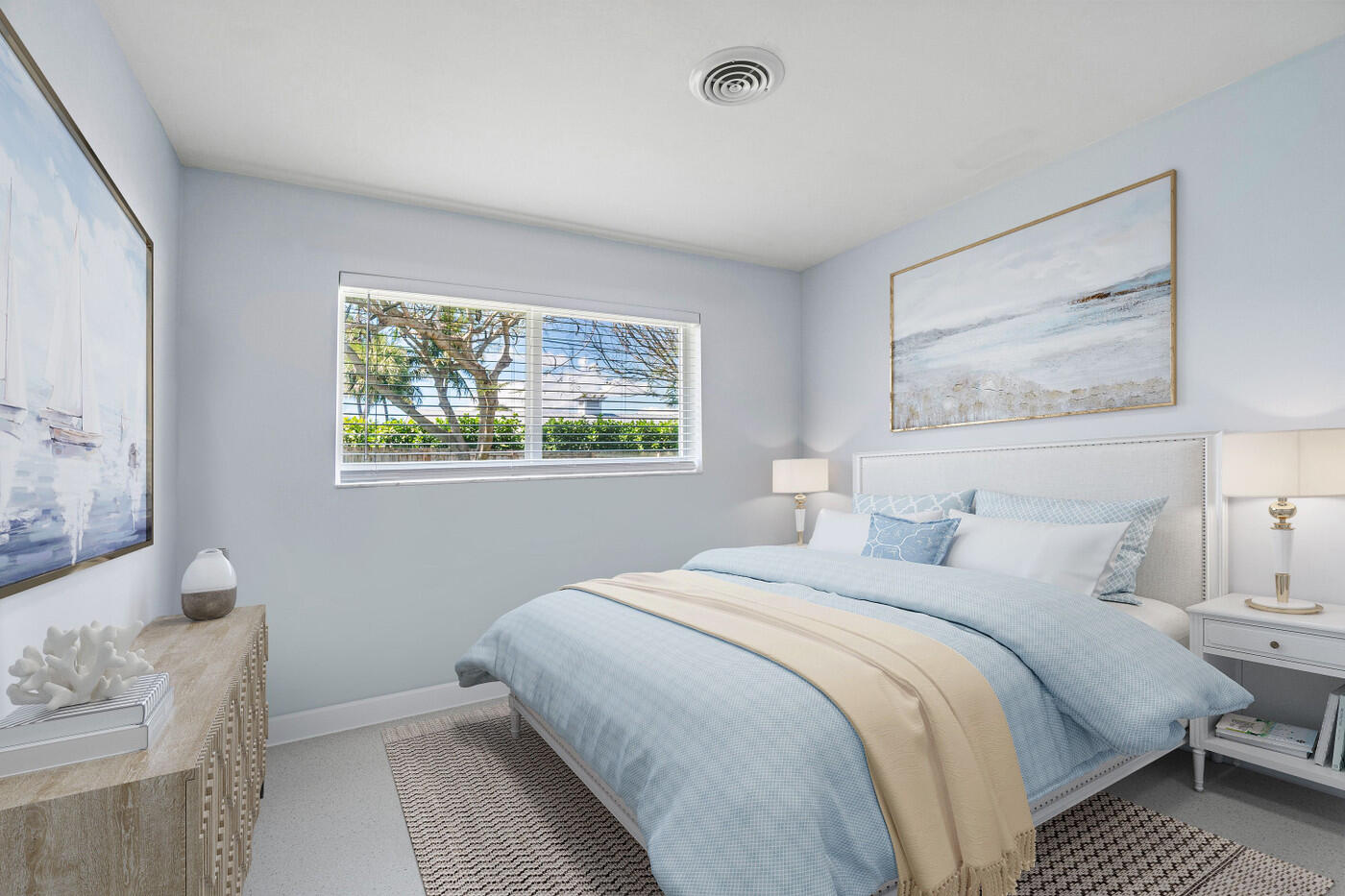 Bright bedroom with a blue-and-white bed and a window overlooking greenery.