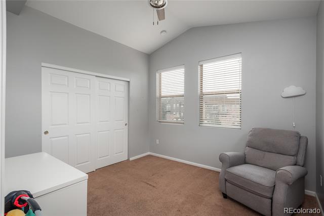 Unfurnished bedroom with two blinded windows, a white closet, and a gray armchair.