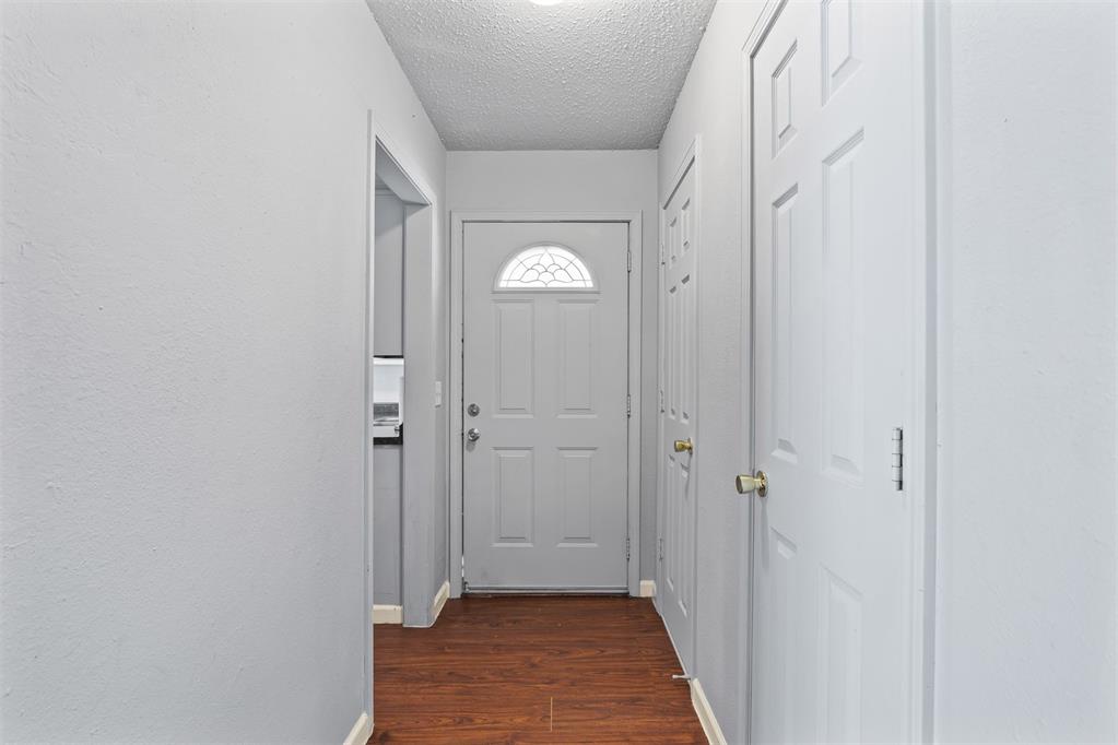 Entry hallway with wood flooring and a front door topped by a semicircular window.