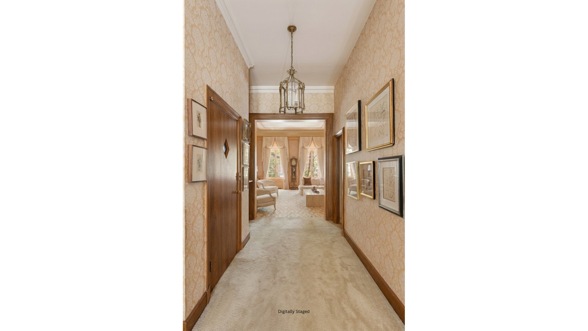 Carpeted hallway with patterned wallpaper and framed art leading to a bright, furnished living room.