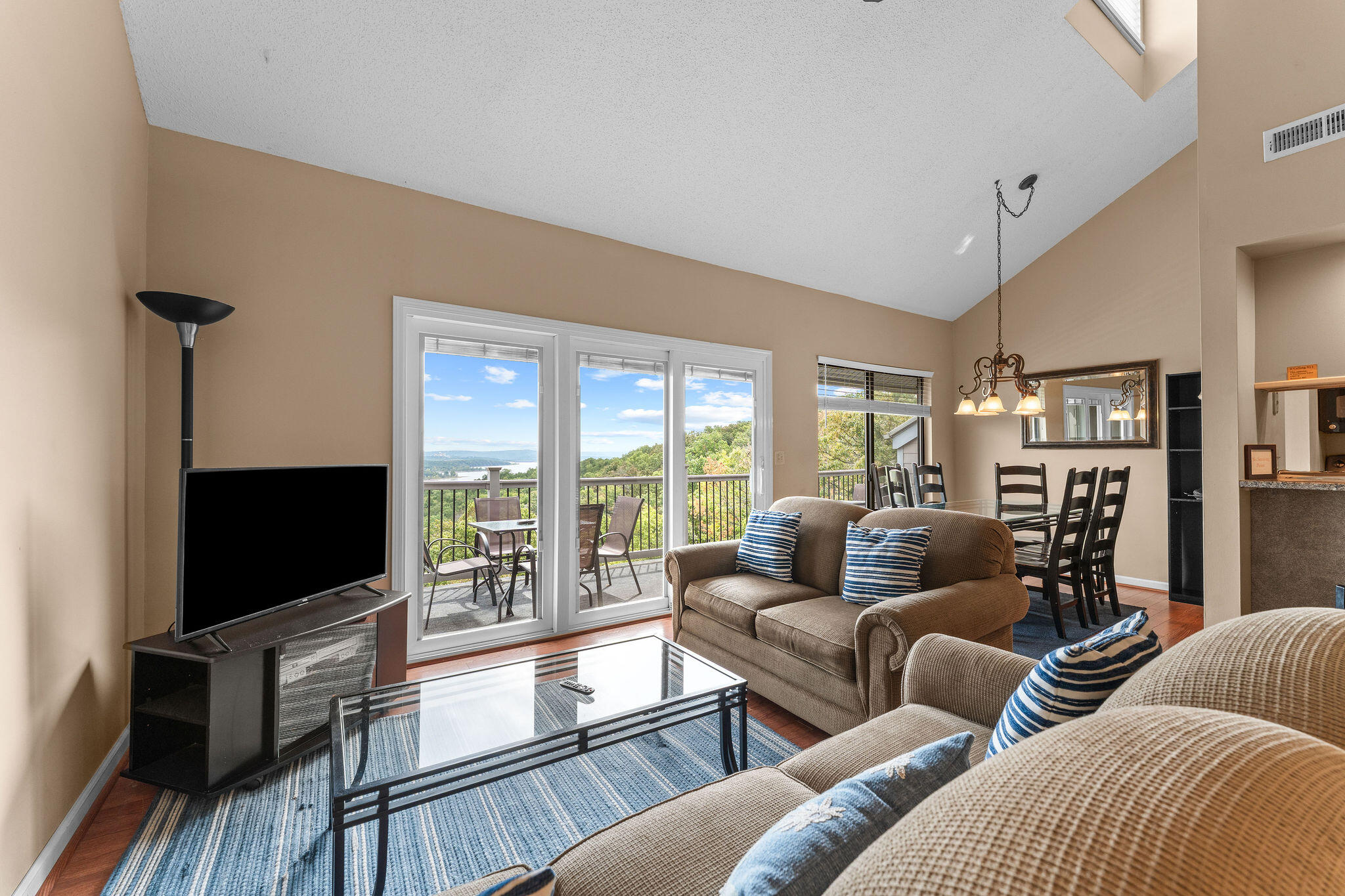 Living room with sliding glass doors opening to a balcony overlooking the water.
