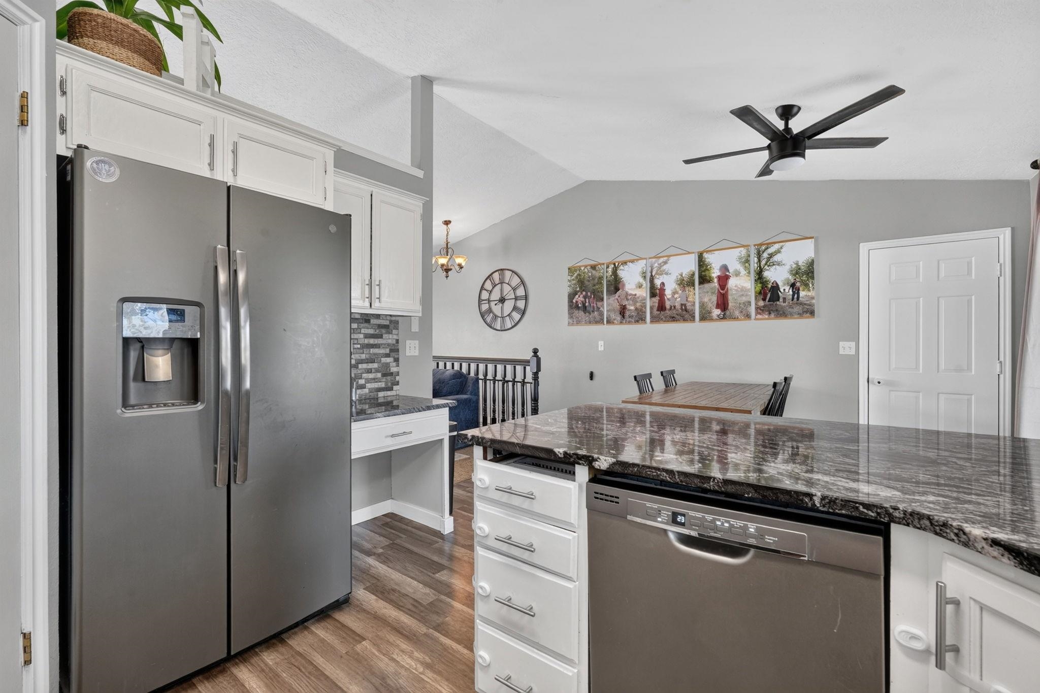 Kitchen with a large stone island, stainless appliances, and an adjoining dining area.