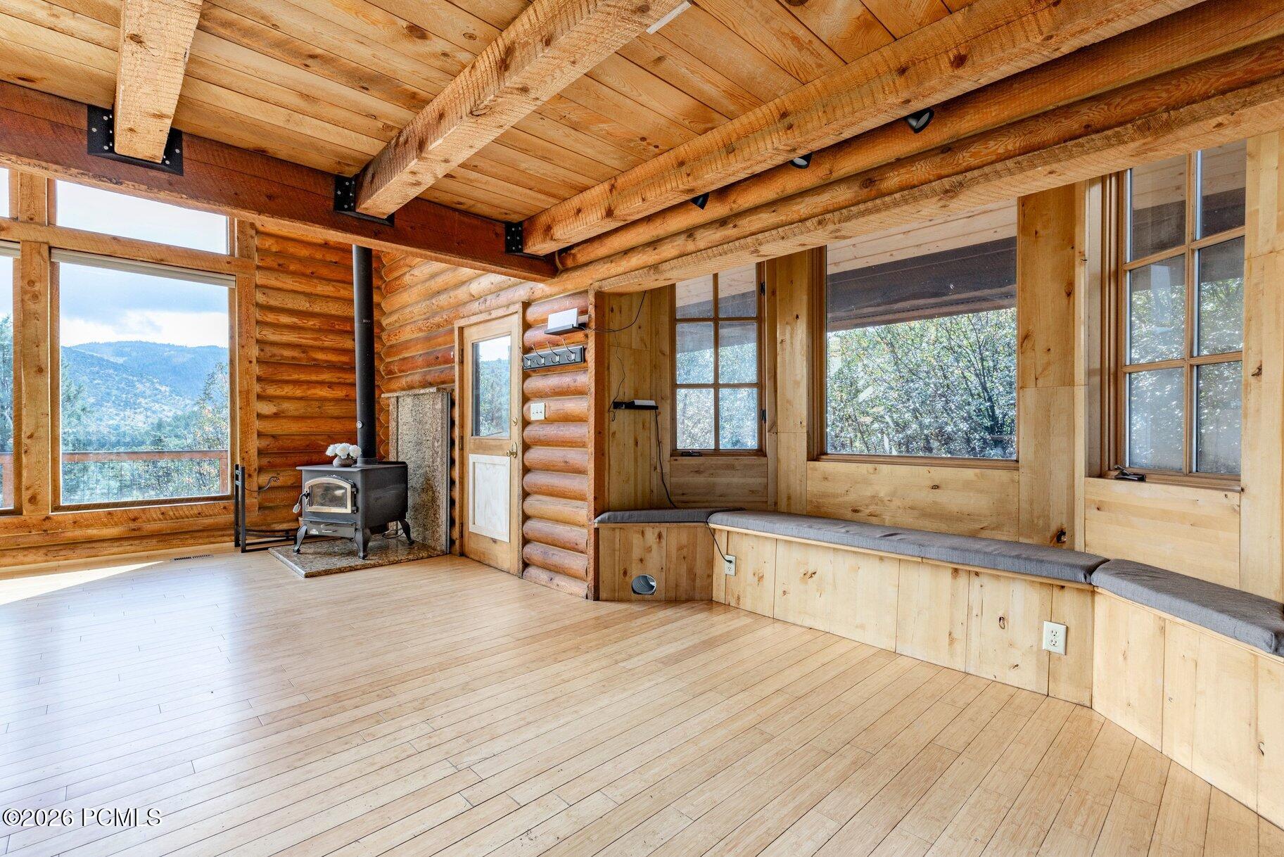 Log-cabin room with a wood stove, built-in window seat, and mountain views.