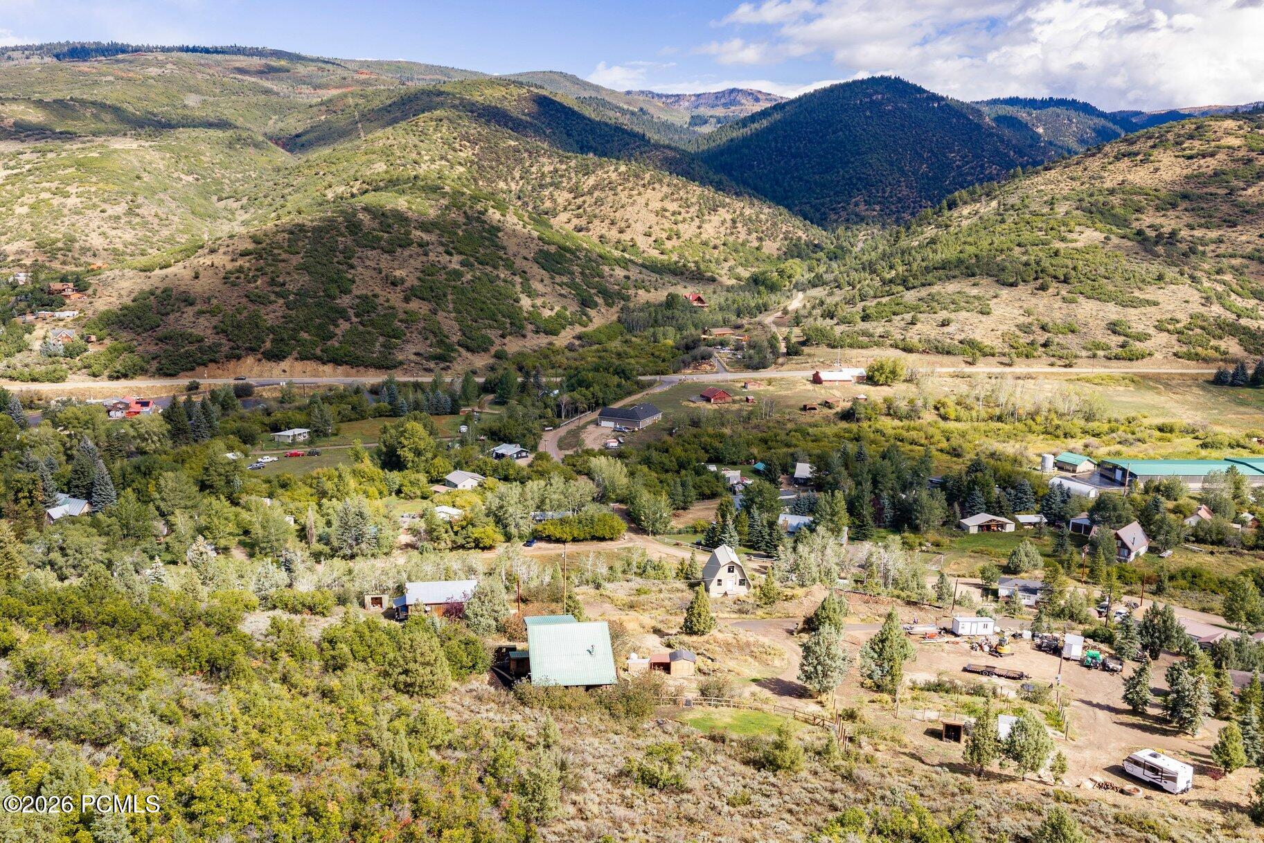 Aerial view across scattered homes in a rural valley surrounded by mountain ridges.