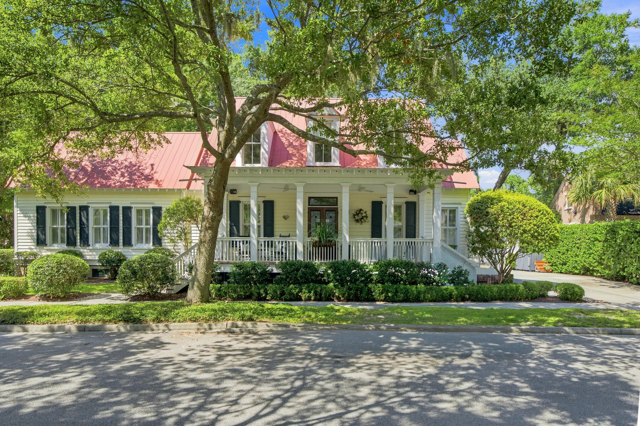 House at 55 Montrose Road with a pink roof, covered porch, and mature trees.