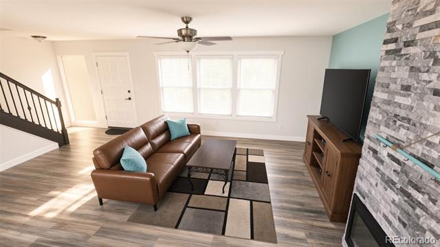 Furnished living room with a brown leather sofa, geometric rug, and stone-faced fireplace.
