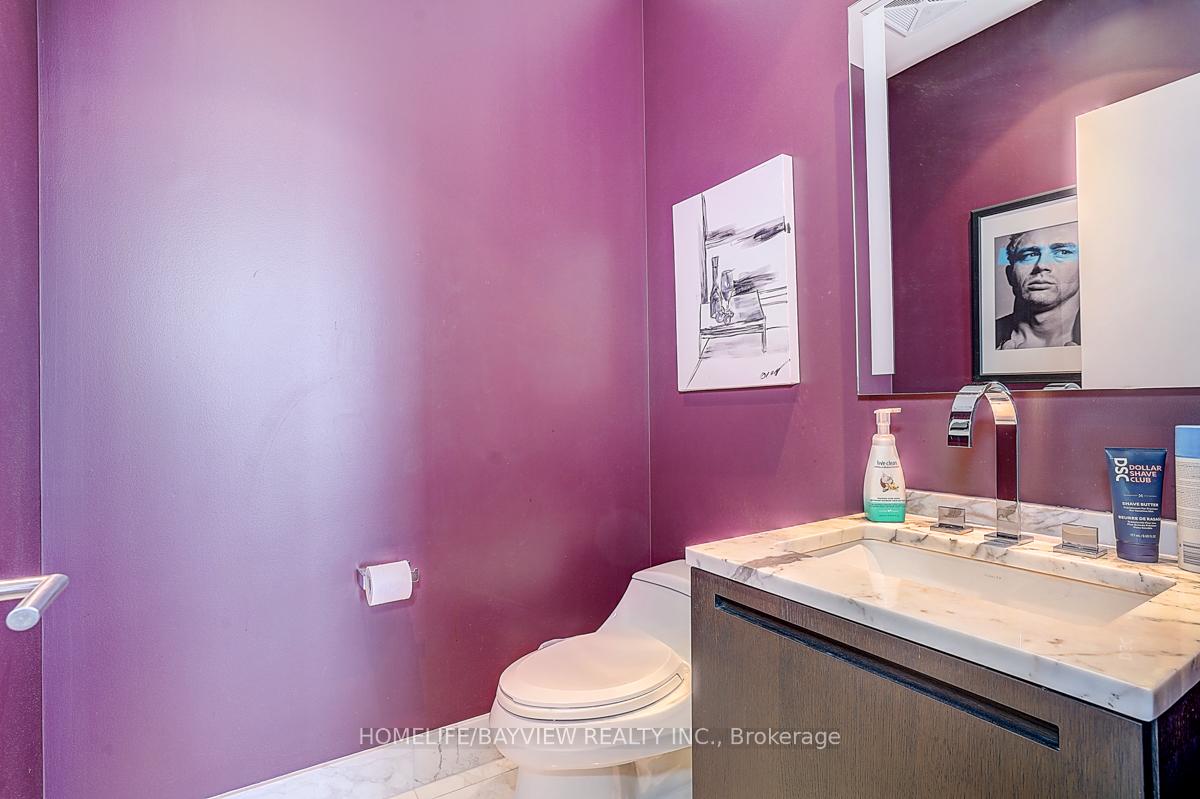 Bathroom with deep purple walls, marble vanity, toilet, and large wall mirror.
