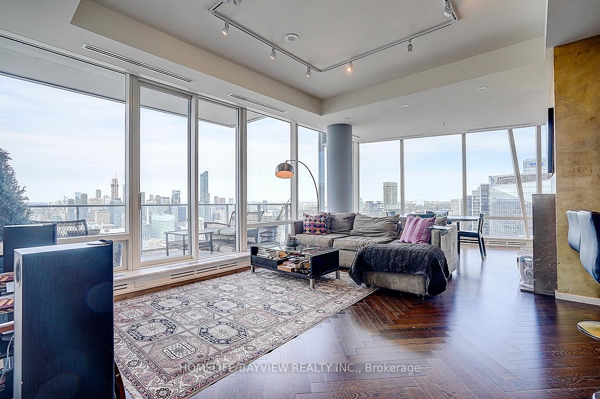 Furnished condo living room with floor-to-ceiling windows overlooking the Toronto skyline.