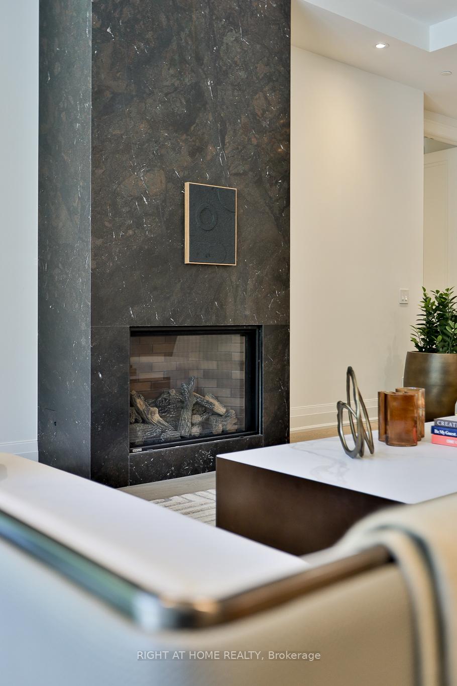 Living room fireplace with a dramatic dark stone surround and white marble coffee table.