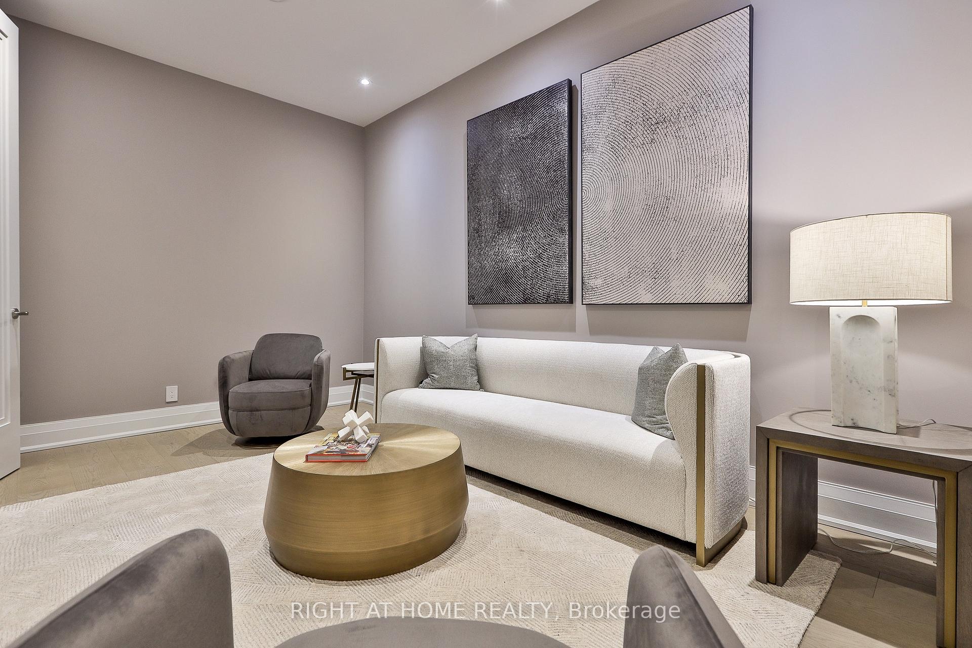 Staged living room with a white sofa, round coffee table, and large abstract wall art.