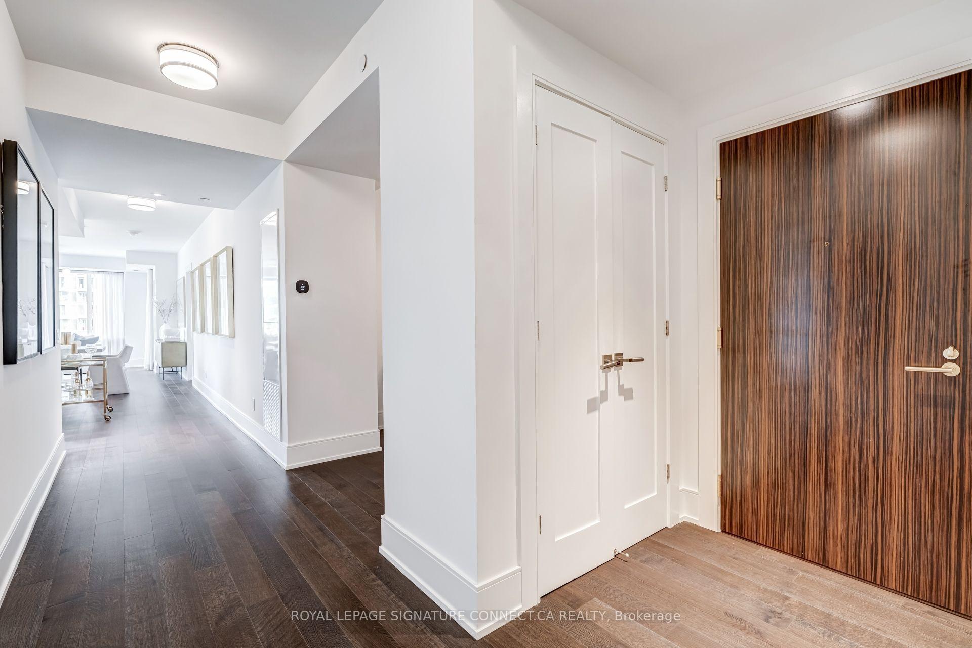 Condominium entry hall with a wood-grain front door and a view toward the living area.