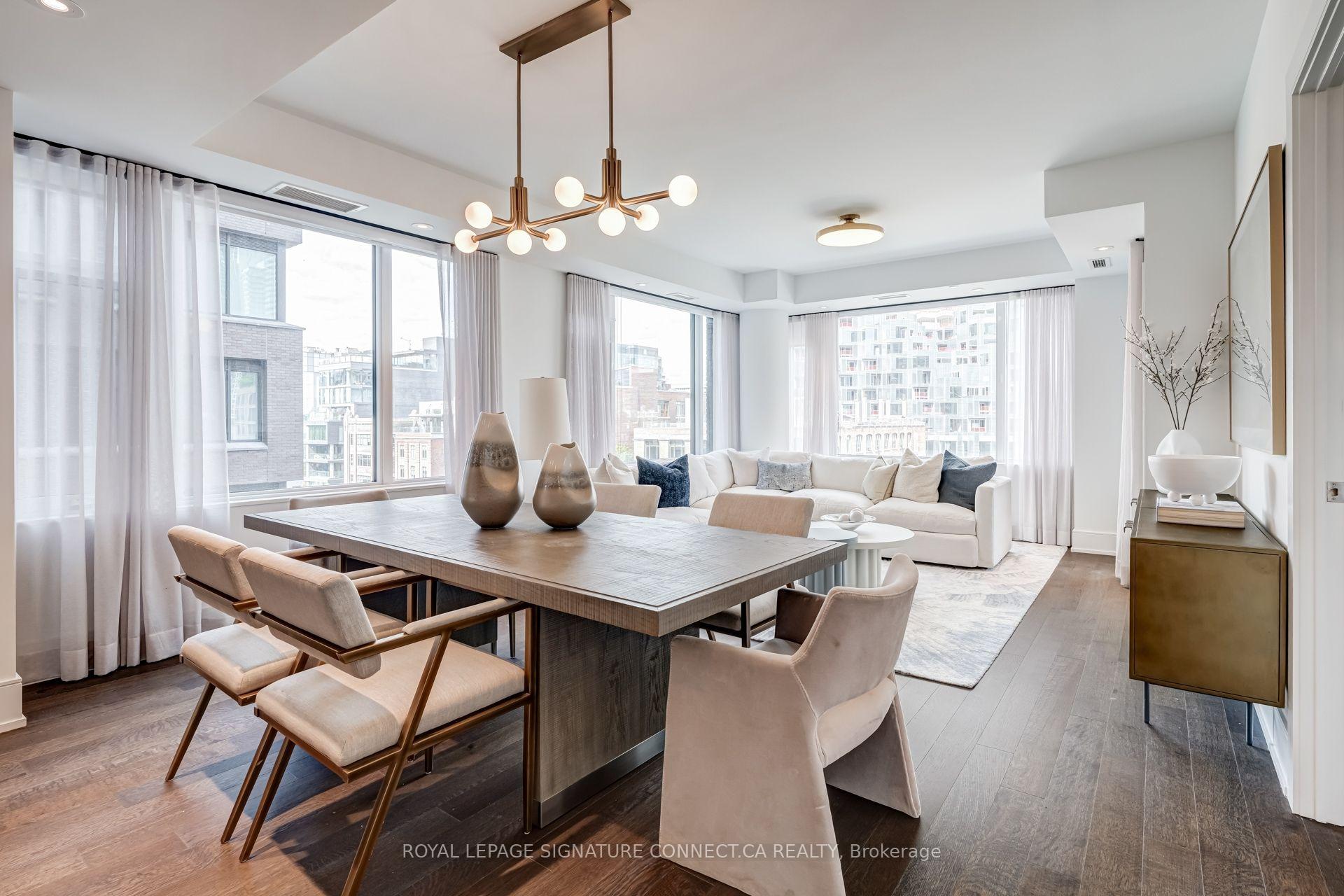 Open-plan condo living and dining room with floor-to-ceiling windows and a white sectional sofa.