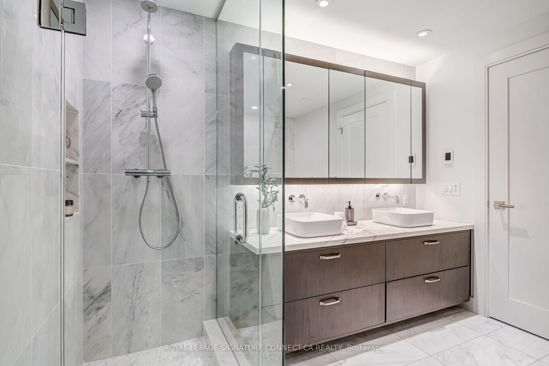 Bathroom with a glass shower and double vanity featuring two vessel sinks.