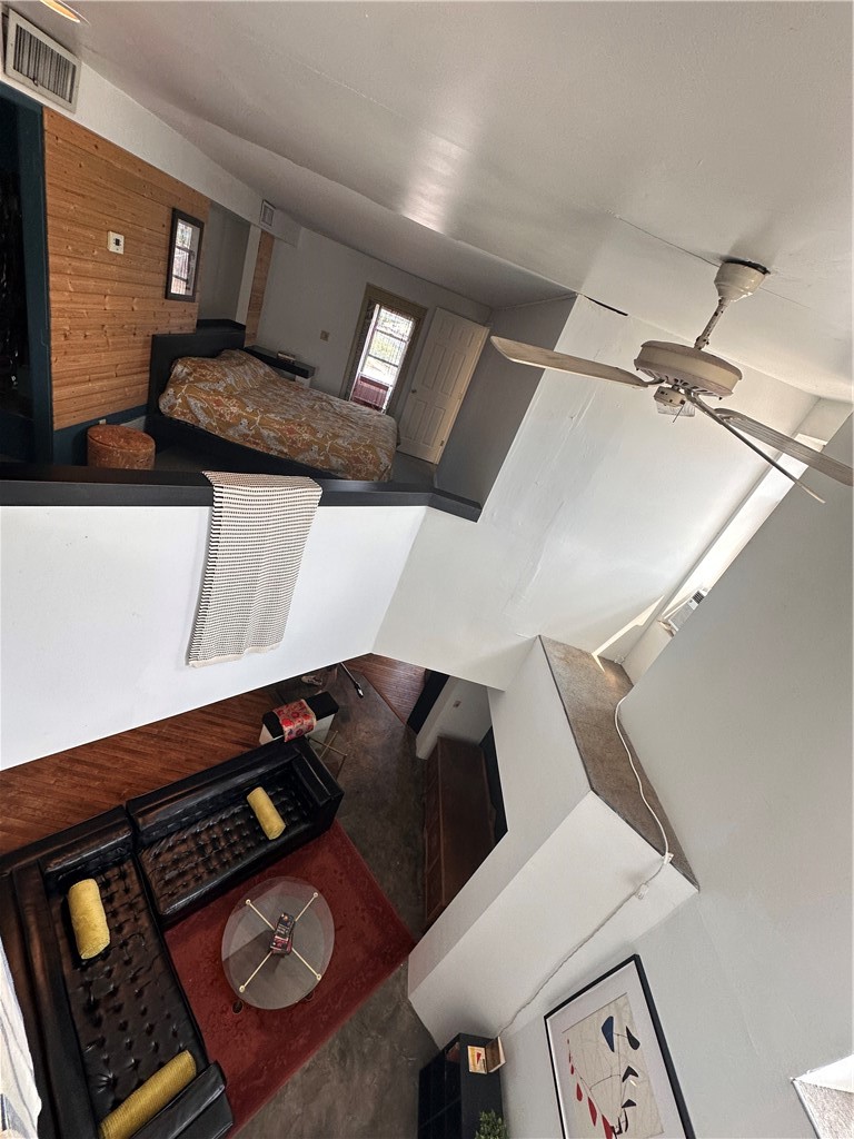 Two-level loft interior with an upper sleeping area and a lower living room with leather sofas.