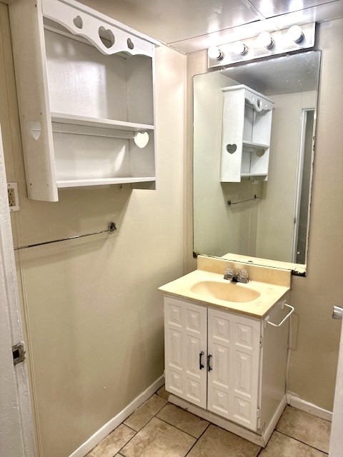 Bathroom with a white vanity, large mirror, and wall cabinet with heart-shaped cutouts.