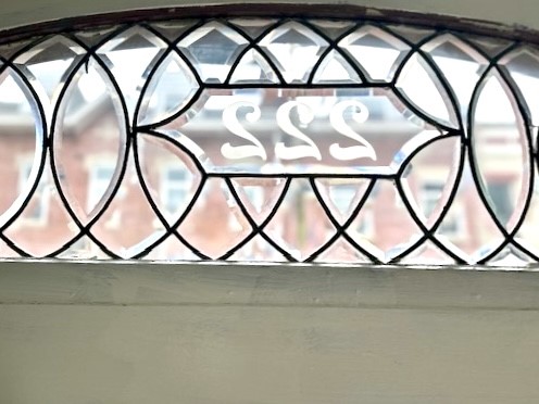 Leaded-glass transom window with the house number 222.