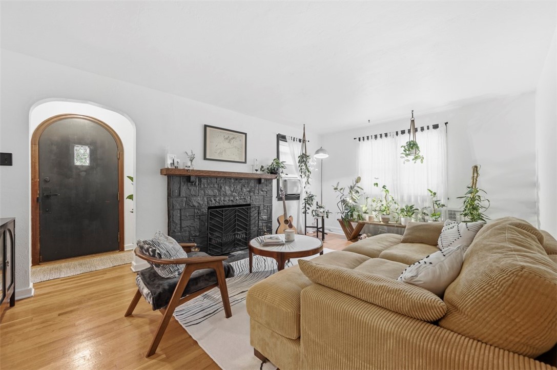 Living room with a black stone fireplace, arched front door, and large tan sectional sofa.