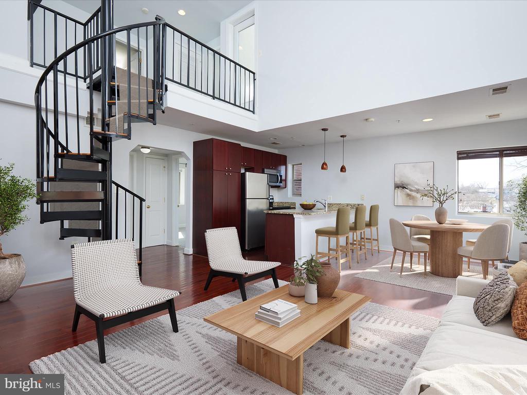 Open-plan condo living area with a black spiral staircase, loft, and adjoining kitchen and dining space.