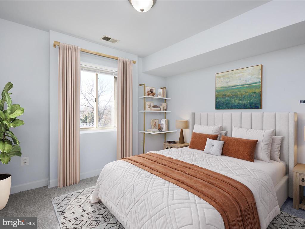 Staged bedroom with a tall upholstered headboard, white quilted bedding, and rust-colored accents.