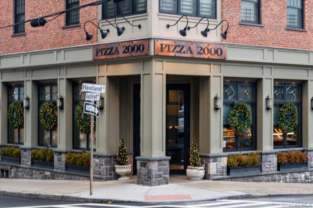 Corner building with a Pizza 2000 storefront, brick upper floors, and Haviland Street and Halstead Avenue signs.