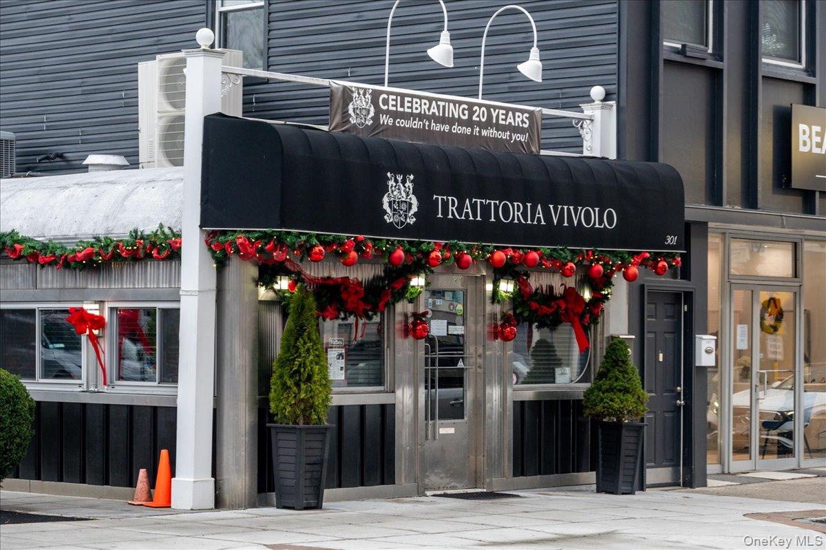 Trattoria Vivolo restaurant storefront decorated with Christmas garlands and red ornaments.