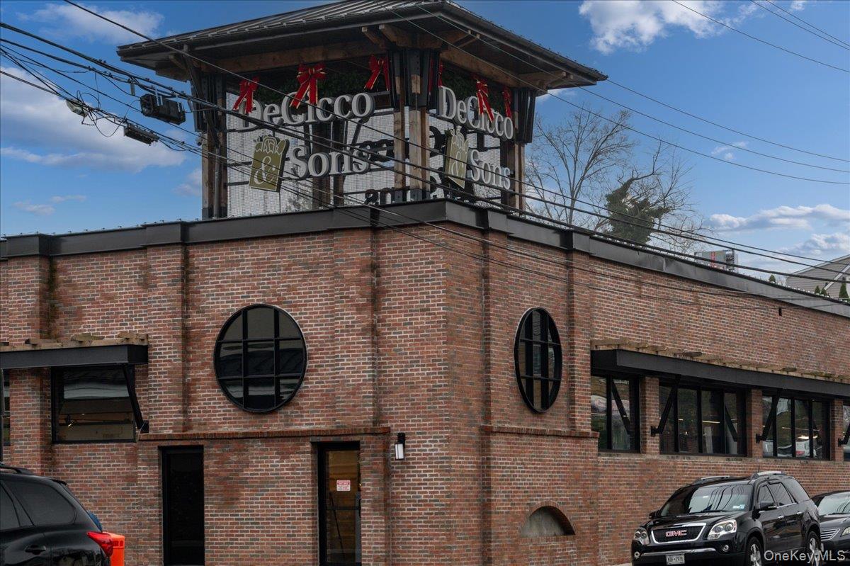Brick commercial building with DeCicco & Sons signs and distinctive round windows.