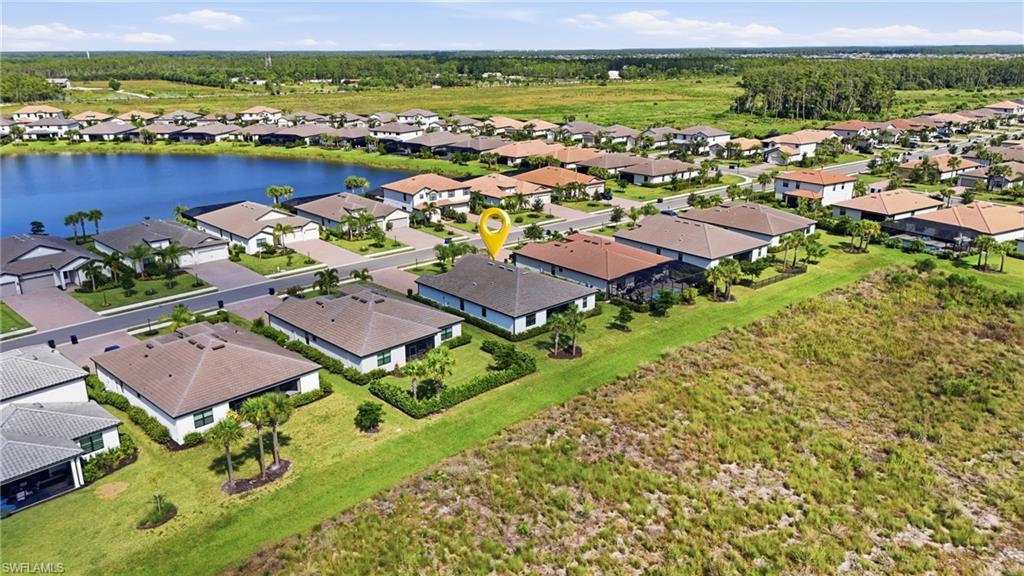 Aerial view of homes beside a lake, with a yellow pin marking one property.