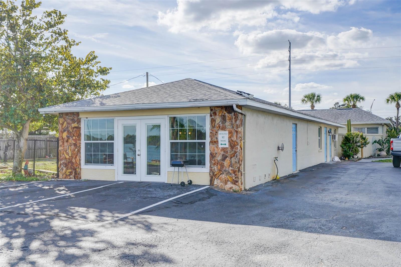 Single-story commercial building with a stone-clad entrance and paved parking area.