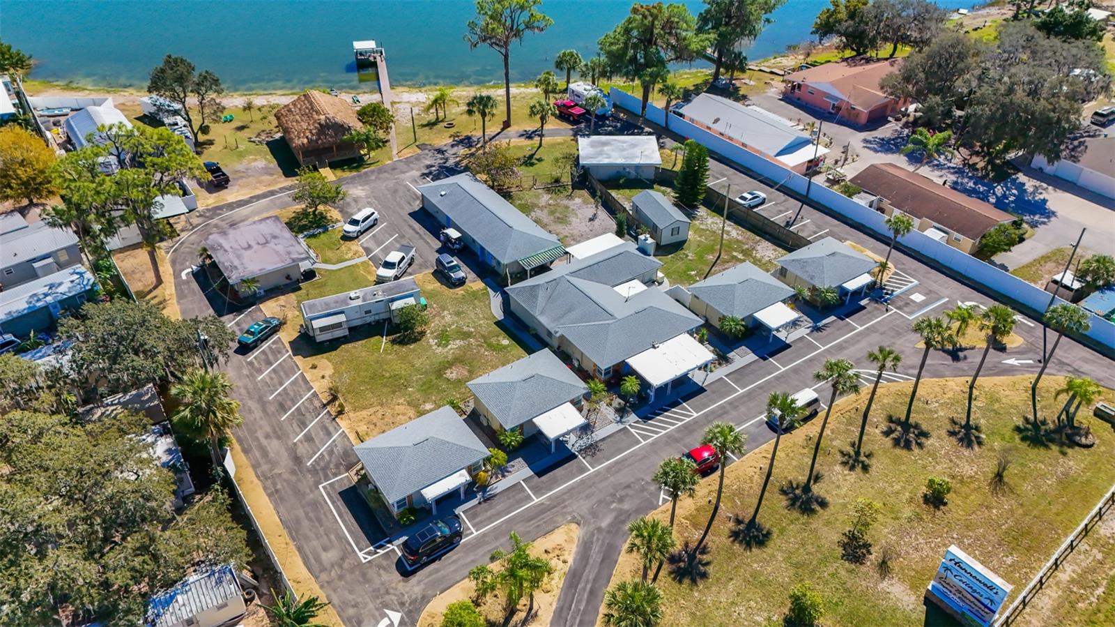 Aerial view of several buildings and parking beside a lake.