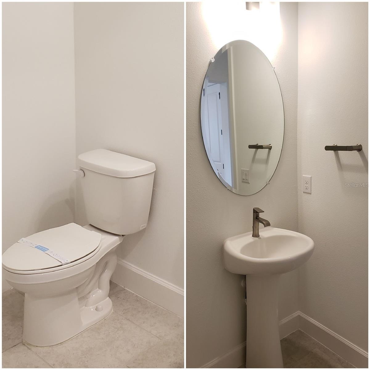 Bathroom with a toilet and a pedestal sink beneath an oval mirror.