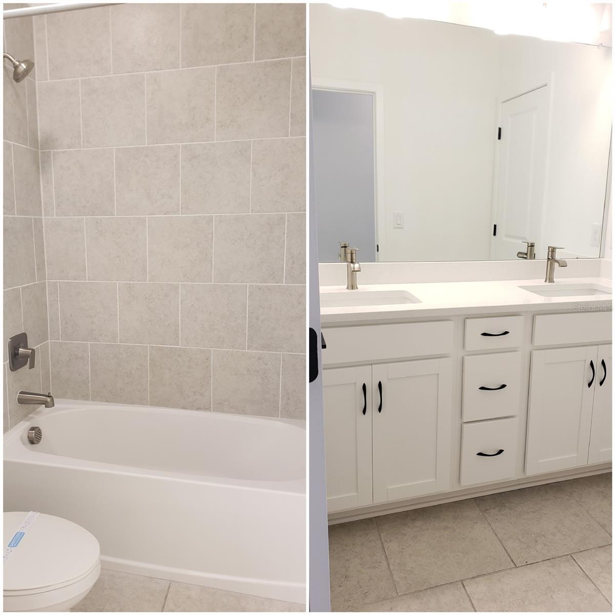 Bathroom with a tiled tub-shower and a white double-sink vanity.