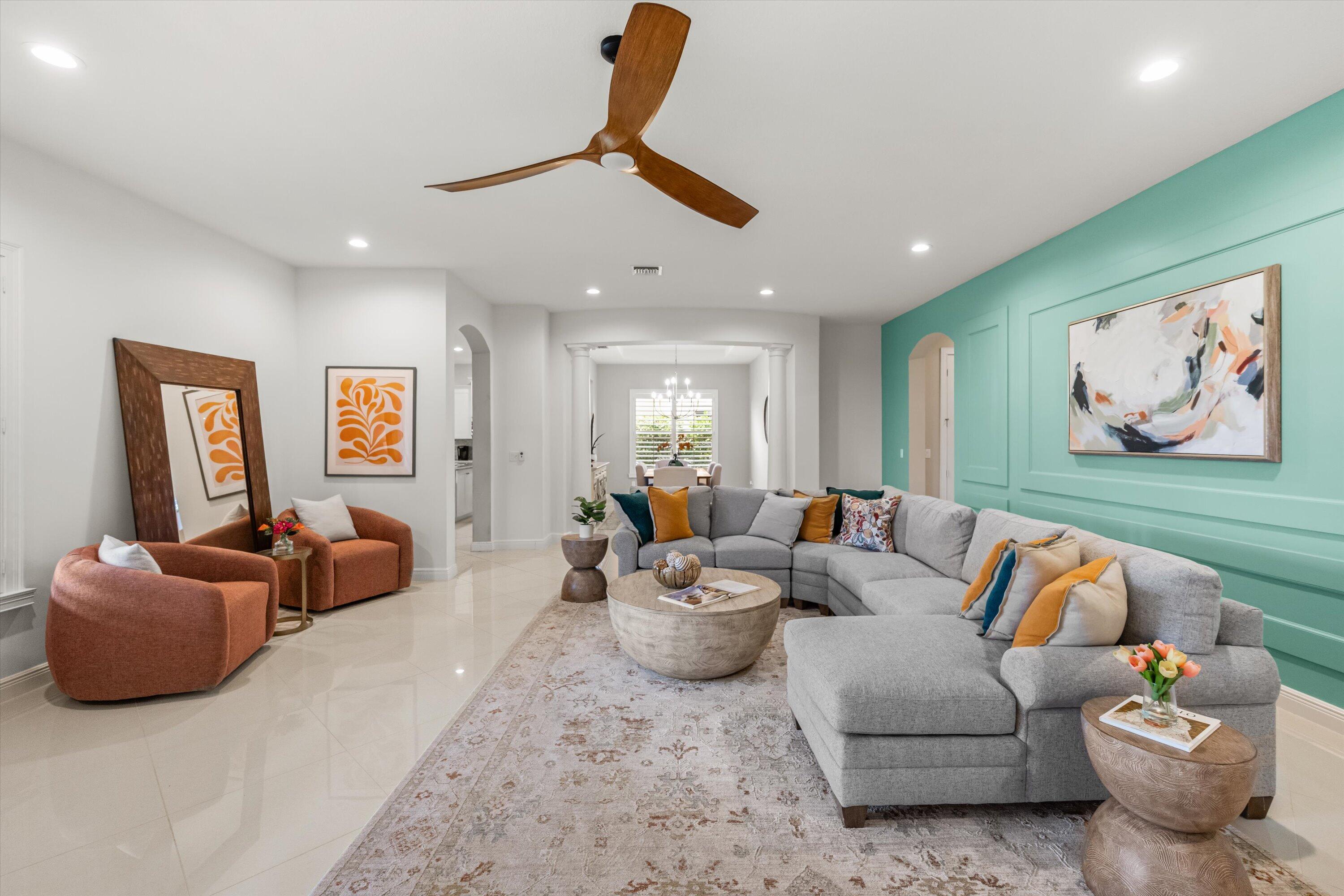 Staged living room with a gray sectional, turquoise accent wall, and rust-colored chairs.