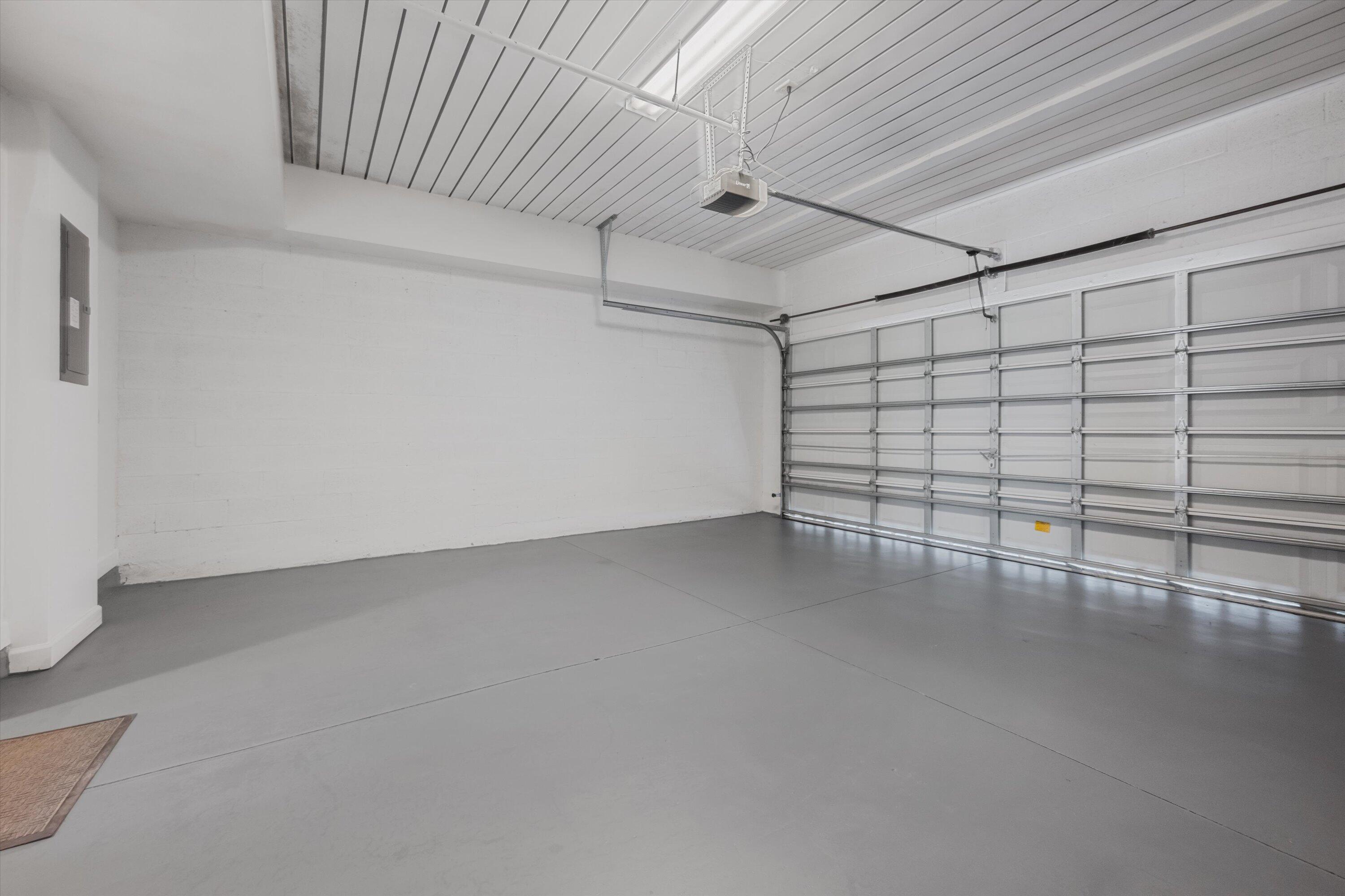 Empty garage with a smooth gray floor and large sectional garage door.