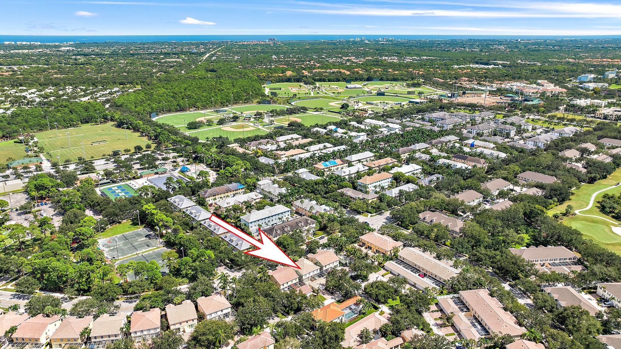 Aerial view of 4110 Parkside Drive, marked by an arrow among homes near sports fields and the coast.